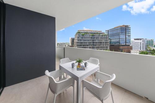 a white table and chairs on a balcony with a view at The Corso - Central Maroochydore Apartment in Maroochydore