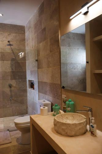 a bathroom with a sink and a toilet and a mirror at Club de Playa Sóol in Telchac Puerto