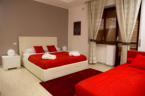 a bedroom with two beds with red sheets and a window at B&B Homedesign in Salerno