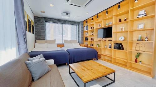 a living room with two beds and a couch at Fierement inn in Sapporo