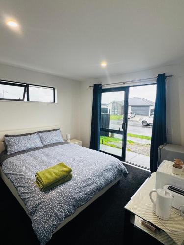 a bedroom with a bed with a green towel on it at Room with en-suite bathroom in Kaiapoi
