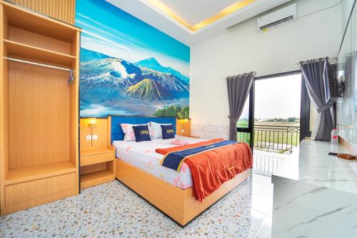a bedroom with a bed and a painting of a mountain at Hotel Tiara By ARBA in Weleri