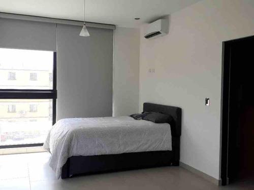 a bedroom with a bed and a large window at Loftstay MYO in Monterrey