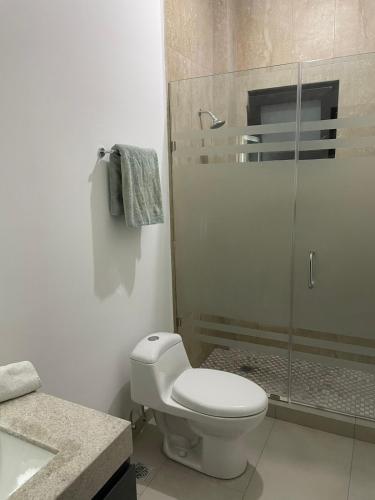 a bathroom with a toilet and a glass shower at Loftstay MYO in Monterrey