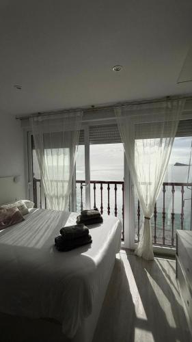 ein Schlafzimmer mit einem Bett vor einem Fenster in der Unterkunft Las Damas Piso18 in Benidorm
