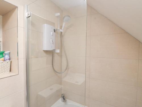 a bathroom with a shower with a glass door at Merlin in Pwllheli