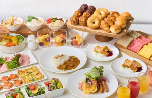 a table filled with plates of food and snacks at Hotel JAL City Fukuoka Tenjin in Fukuoka