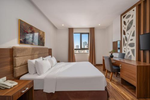 a hotel room with a bed and a desk and a computer at Lumina Hotel & Apartment in Danang