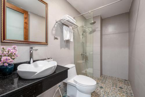 a bathroom with a sink and a toilet and a shower at Lumina Hotel & Apartment in Danang