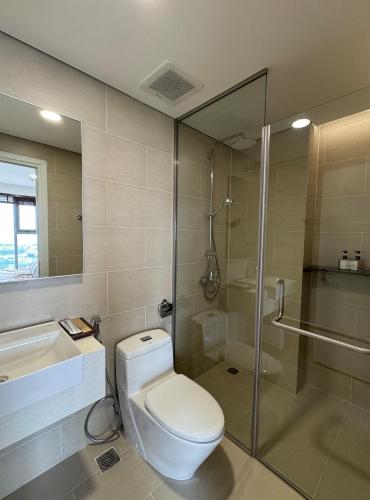 a bathroom with a toilet and a shower and a sink at CARTER Flat in Ho Chi Minh City