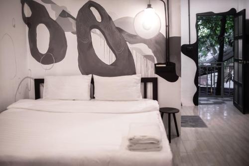 a bedroom with a bed with a sign on the wall at MESTO Koh Phangan - Creative Stay & Community Hub in Thong Sala