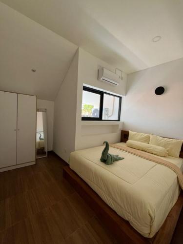 a bedroom with a large bed with a green frog on it at Naung CoLiving in Kerobokan