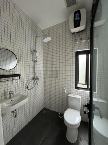a bathroom with a white toilet and a sink at Naung CoLiving in Kerobokan