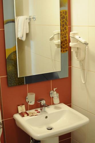 a bathroom with a white sink and a mirror at Millenium Palace in Ohrid
