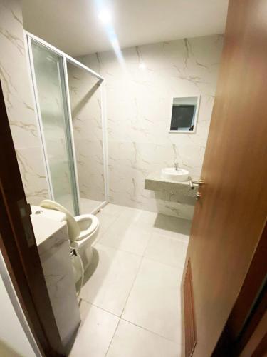 a bathroom with a toilet and a sink at Grand Kamala Lagoon by Whitebox in Bekasi