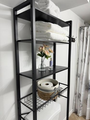 a black shelf with towels and a basket at Private Apartment for Business & Couples in Sudbury