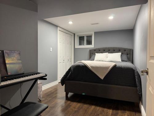 a bedroom with a bed and a desk with a keyboard at Private Apartment for Business & Couples in Sudbury