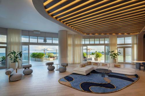 a lobby with a couch and tables and windows at W Fort Lauderdale in Fort Lauderdale