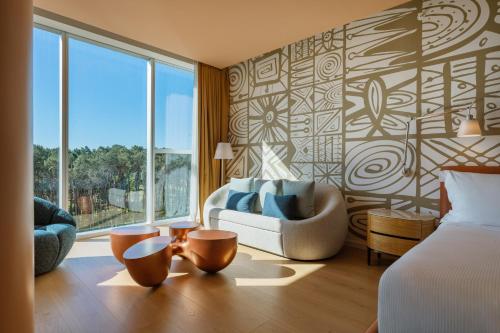 a bedroom with a bed and a chair and a window at The Grand Hotel in Punta del Este