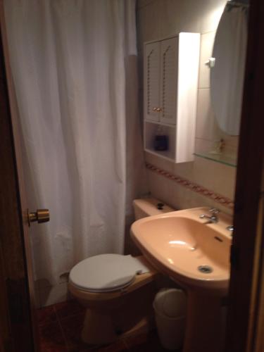 W łazience znajduje się toaleta, umywalka i lustro. w obiekcie Turquesa w mieście El Quisco
