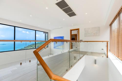 a glass staircase in a house with a view at Chaweng Noi villa Managed by Saitara peak in Chaweng Noi Beach