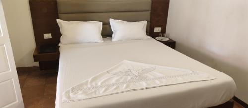 a bed with a white blanket with a butterfly on it at Le Aham Boutique Hotel in Kuilapayam