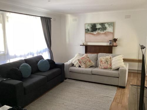 a living room with a black couch and a grey couch at Weekend Escape in Rosebud
