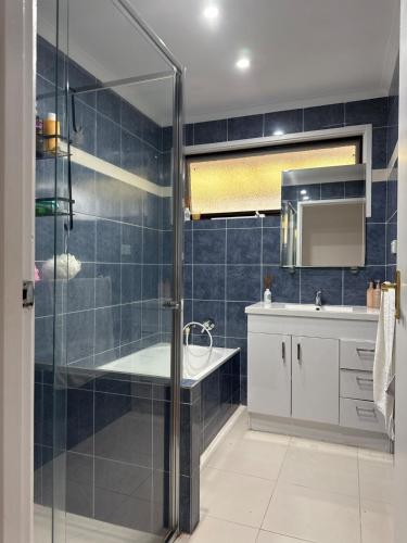 a bathroom with a shower and a tub and a sink at Weekend Escape in Rosebud