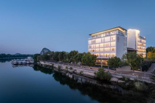 a rendering of a building next to a river at GUILIN LI RIVER CIAO Hotel in Guilin