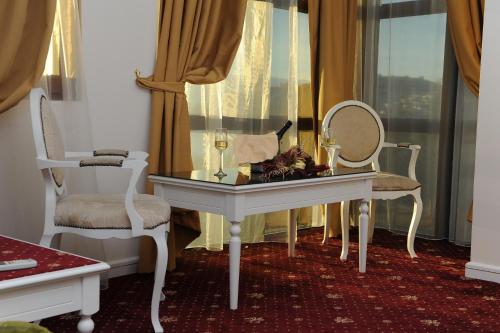 a room with a table with a mirror and two chairs at Millenium Palace in Ohrid