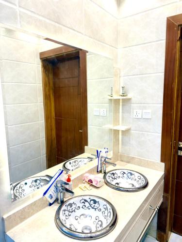 a bathroom with two sinks and a mirror at شاليهات حياة روز in Taif