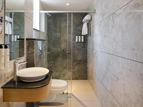 a bathroom with a sink and a shower at Regenta Z Vadodara in Vadodara