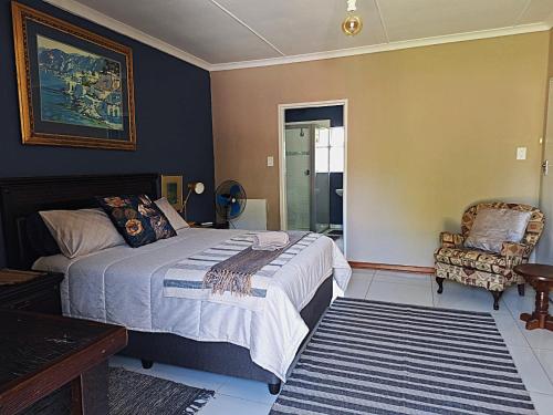 a bedroom with a bed and a chair at The Pebble in Howick