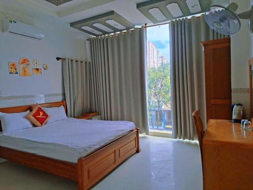 a bedroom with a bed and a large window at Khách Sạn FLORÉA in Phan Rang–Tháp Chàm