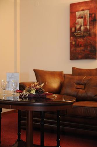 a living room with a leather couch and a table at Millenium Palace in Ohrid