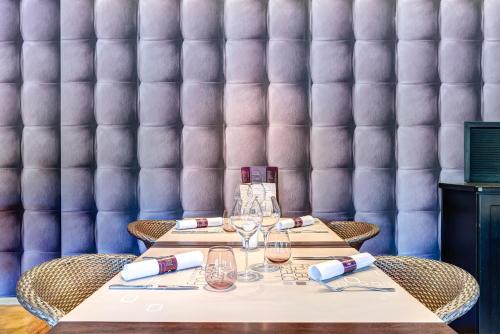 a table in a restaurant with a purple wall at RAVeL Hotel Cyrano in Waimes