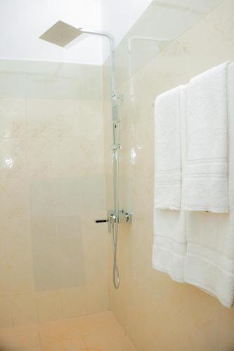 a bathroom with a shower with a white towel at Samaya Waters Bentota in Haburugala
