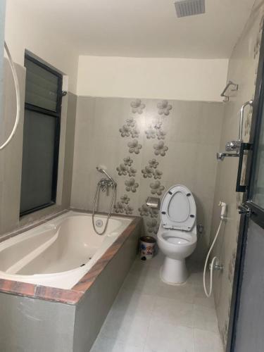 a bathroom with a bath tub and a toilet at Hotel Indrawoti and Resort in Dhulikhel