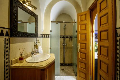 a bathroom with a sink and a shower with a mirror at Riad Zaki Marrakech in Marrakesh
