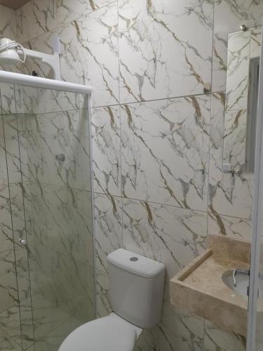a bathroom with a toilet and a shower and a sink at Pousada-Suítes Alto do Moura in Caruaru
