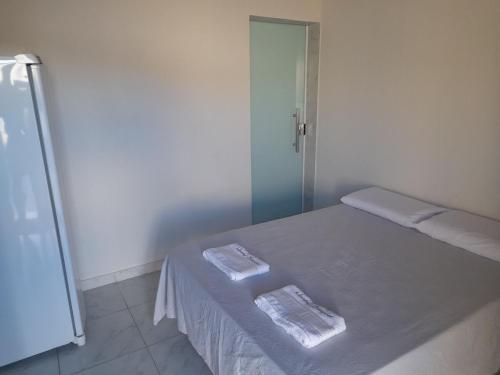 a bedroom with a bed with two towels on it at Pousada-Suítes Alto do Moura in Caruaru