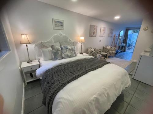 a bedroom with a large white bed and a chair at Salty Kisses in Narrabeen