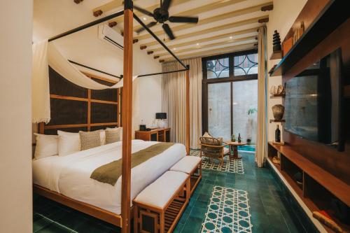 ein Schlafzimmer mit einem großen Bett und einem Fernseher in der Unterkunft CIGNO Mejorada Hotel Boutique in Mérida