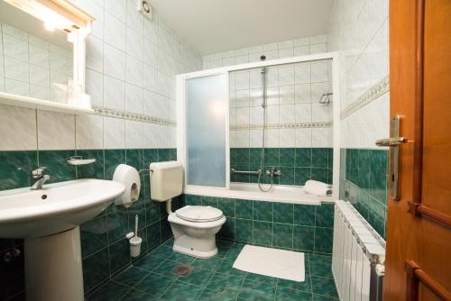 een groene en witte badkamer met een toilet en een wastafel bij Hotel Lagus in Varaždin