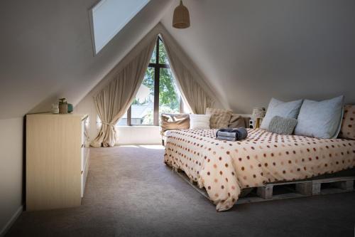 a bedroom with a bed and a large window at Stunning cottage in Christchurch