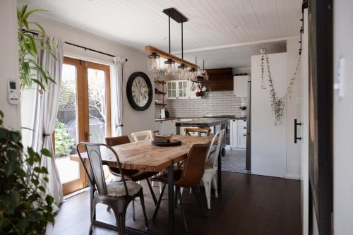 a kitchen and dining room with a wooden table and chairs at Stunning cottage in Christchurch