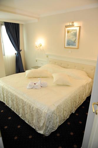a bedroom with a bed with two towels on it at Millenium Palace in Ohrid
