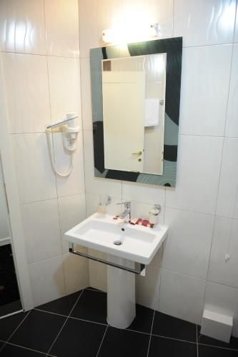 a bathroom with a white sink and a mirror at Millenium Palace in Ohrid