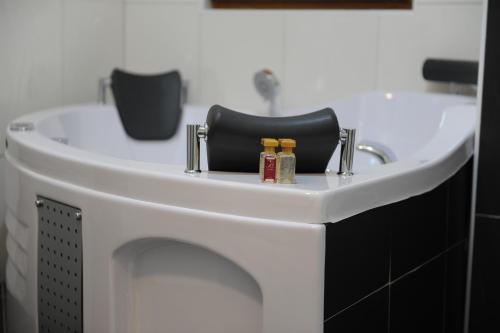 a bathroom sink with a black chair and two bottles at Millenium Palace in Ohrid