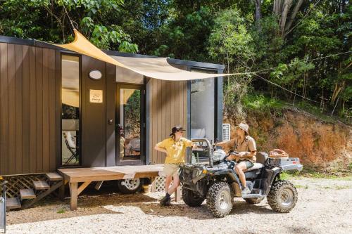 two men on a atv parked next to a tiny house at Raspberry Spring Corner by Tiny Away in Clothiers Creek